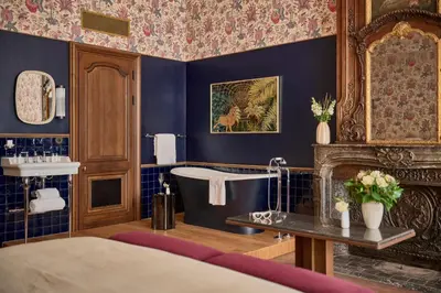 a bathroom with a bed and a tub and a fireplace at Faubourg 21 in Brussels