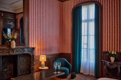 a room with a blue chair and a window at Faubourg 21 in Brussels