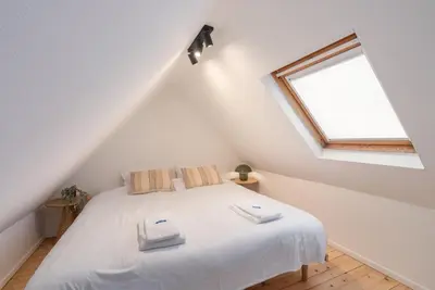 a bedroom with a white bed with two towels on it at Gezellig, knusse en gerenoveerde rijwoning 4p in Ghent