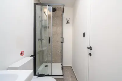 a glass shower in a bathroom with a toilet at Gezellig, knusse en gerenoveerde rijwoning 4p in Ghent