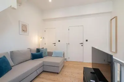 a living room with a gray couch and blue pillows at Gezellig, knusse en gerenoveerde rijwoning 4p in Ghent