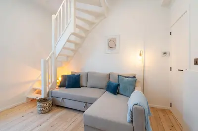 a living room with a couch and a staircase at Gezellig, knusse en gerenoveerde rijwoning 4p in Ghent
