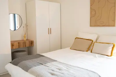 a bedroom with a white bed with two pillows at Studio Herman met buitenterras in Kapellenbos, bij de Kalmthoutse Heide in Kapellen