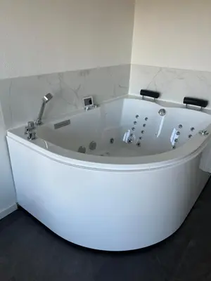 a white bath tub in a room with marble walls at Jacuzzi & free parking at Andries Place in Antwerp