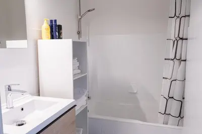 a white bathroom with a sink and a shower at Jacuzzi & free parking at Andries Place in Antwerp
