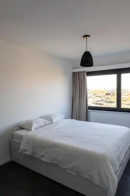 a bedroom with a white bed and a window at Jacuzzi & free parking at Andries Place in Antwerp