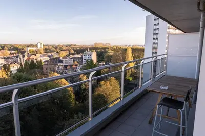 a balcony with a table and a chair on a building at Jacuzzi & free parking at Andries Place in Antwerp