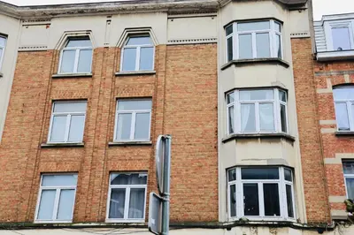 a red brick building with white windows at YabaMuandaz Apparts de Standing & Confort in Brussels
