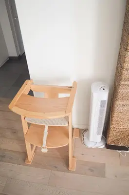 a wooden chair sitting next to a heater in a room at 1BR apt métro Hopital Erasme Bordet handicapt friendly in Brussels
