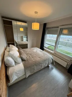 a bedroom with a large bed and a large window at Air Bey Penthouse in Brussels
