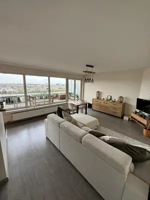 a living room with a white couch and a large window at Air Bey Penthouse in Brussels