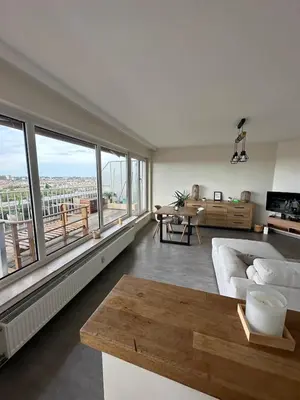 a living room with a couch and a large window at Air Bey Penthouse in Brussels