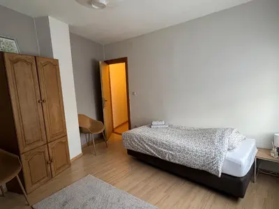 a bedroom with a bed and a cabinet and a table at Centrally located house for six in Rumst