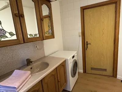 a bathroom with a sink and a washing machine at Centrally located house for six in Rumst