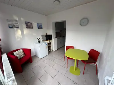 a living room with a green table and red chairs at Appartement cosy à Bruxelles métro Vandervelde in Brussels