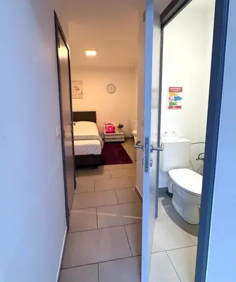 a bathroom with a toilet and a bed in a room at Appartement cosy à Bruxelles métro Vandervelde in Brussels