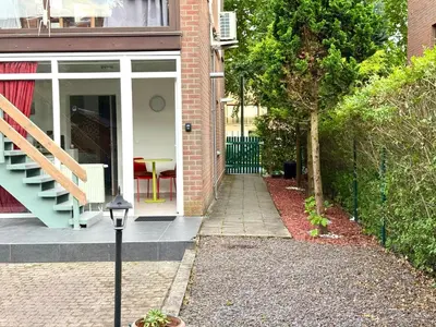 a house with a staircase and a porch with a table at Appartement cosy à Bruxelles métro Vandervelde in Brussels