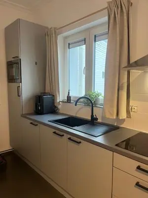 a kitchen with a sink and a microwave and a window at Bloss III Zonnige studio met dakterras in Ghent