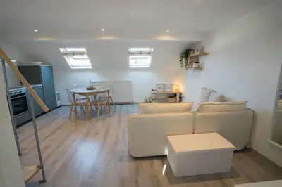 a living room with a white couch and a table at Cosy duplex in Brussels in Brussels
