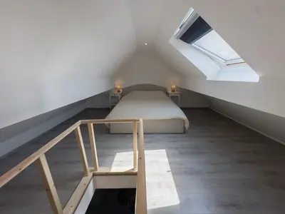 a attic bedroom with a bed and a window at Cosy duplex in Brussels in Brussels