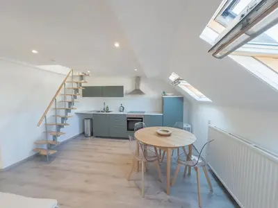 a kitchen and dining room with a table and a staircase at Cosy duplex in Brussels in Brussels