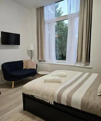 a bedroom with a bed and a chair and a window at Studio Brussels centre in Brussels