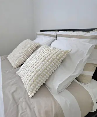 a white bed with four pillows on it at Studio Brussels centre in Brussels