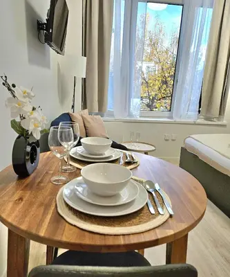 a wooden table with plates and wine glasses on it at Studio Brussels centre in Brussels