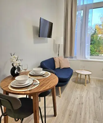 a living room with a table and a blue couch at Studio Brussels centre in Brussels