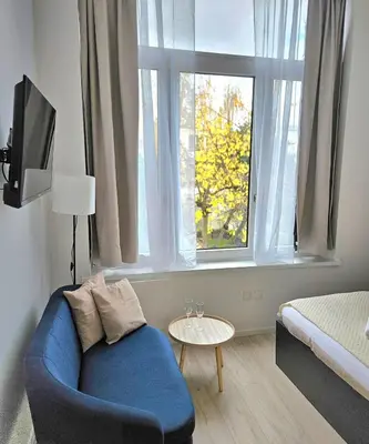 a living room with a blue couch and a window at Studio Brussels centre in Brussels