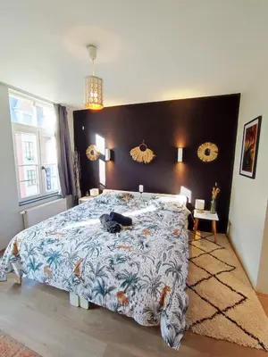 a bedroom with a large bed with a blue comforter at Dodo Guest House in Brussels