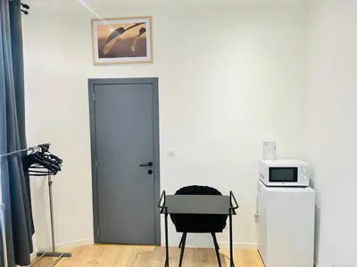 a room with a door and a chair and a microwave at Apparts de standing Bruxelles Brady Muandaz in Brussels