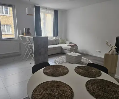 a white living room with a table and chairs at Brussels apartment with terrace 1 in Brussels