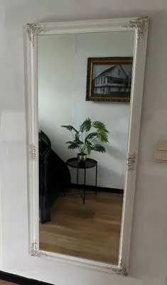 a mirror in a room with a table and a plant at B&B Het Routehuis in Hulshout