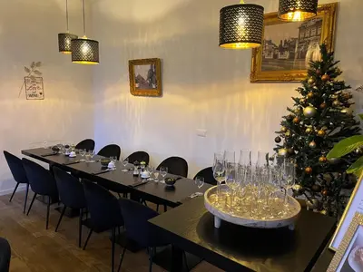 a long table with a christmas tree in a room at B&B Het Routehuis in Hulshout