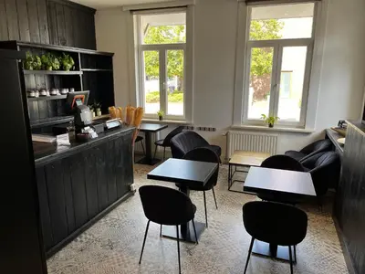 a restaurant with tables and chairs in a room at B&B Het Routehuis in Hulshout