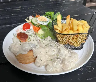 a plate of food with a sandwich and french fries at B&B Het Routehuis in Hulshout