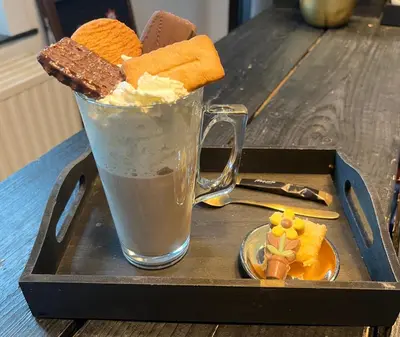 a tray with a glass of ice cream and a chocolate shake at B&B Het Routehuis in Hulshout