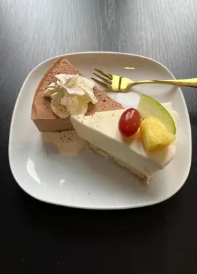 a white plate with a piece of cake and a fork at B&B Het Routehuis in Hulshout