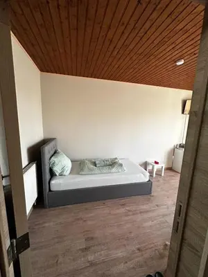 a bed in a room with a wooden ceiling at Antwerp SportPlaza in Antwerp