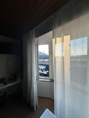 a bedroom with a window with a white car outside at Antwerp SportPlaza in Antwerp