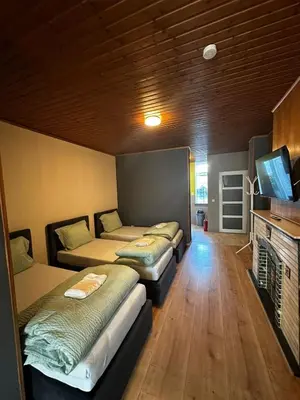 a room with three beds and a flat screen tv at Antwerp SportPlaza in Antwerp
