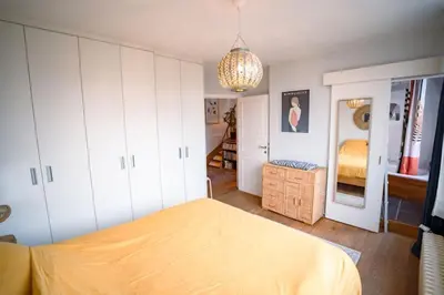 a bedroom with a bed and a chandelier at Appartement 2 chambres avec rooftop suspendu au Cimetière d'Ixelles in Brussels
