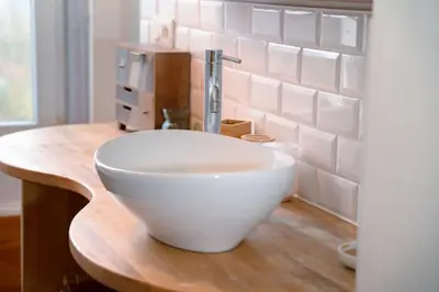 a bathroom with a bowl sink on a wooden counter at Appartement 2 chambres avec rooftop suspendu au Cimetière d'Ixelles in Brussels