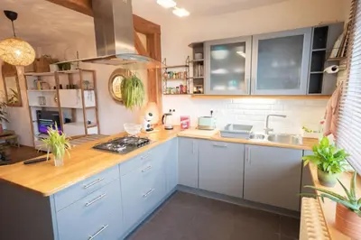 a kitchen with blue cabinets and wooden counter tops at Appartement 2 chambres avec rooftop suspendu au Cimetière d'Ixelles in Brussels