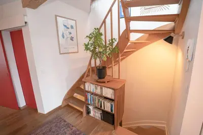 a staircase with a book shelf with a potted plant at Appartement 2 chambres avec rooftop suspendu au Cimetière d'Ixelles in Brussels