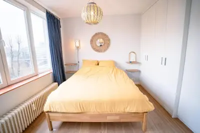 a bedroom with a bed and a chandelier at Appartement 2 chambres avec rooftop suspendu au Cimetière d'Ixelles in Brussels