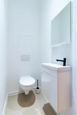 a white bathroom with a toilet and a sink at Sleek City Stays - Urban Elegance in the Heart of Ghent in Ghent