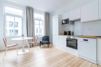 a kitchen with a table and two chairs and a table at Sleek City Stays - Urban Elegance in the Heart of Ghent in Ghent