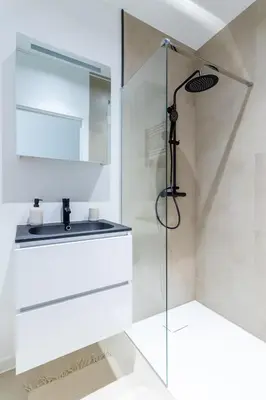 a bathroom with a shower with a glass door at Sleek City Stays - Urban Elegance in the Heart of Ghent in Ghent